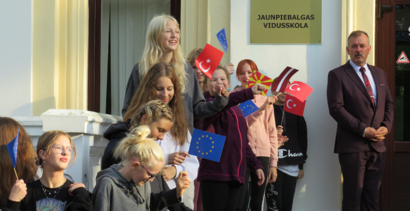 Bērni stāv trpēm ar dažādu valstu karodziņiem