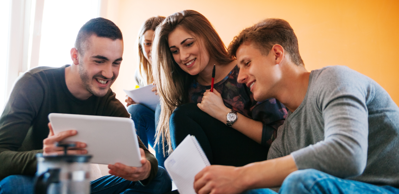 Studenti bariņā skatās planšetdatorā