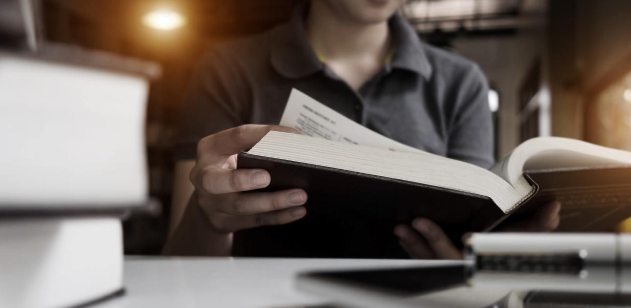 Students atrodas bibliotēka un lasa grāmatu