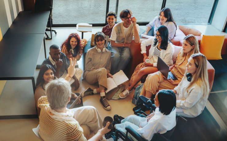 jauniešu grupa sēž kopā ar skolotāju, diskutē